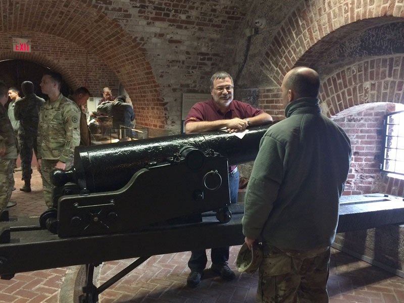 People gathered inside the Harbor Defense Museum and conversating with one another.